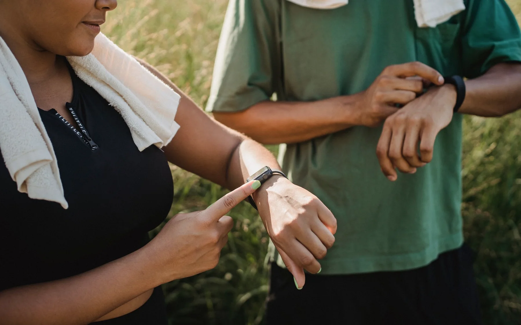 Two workout partners comparing their fitness watches after training