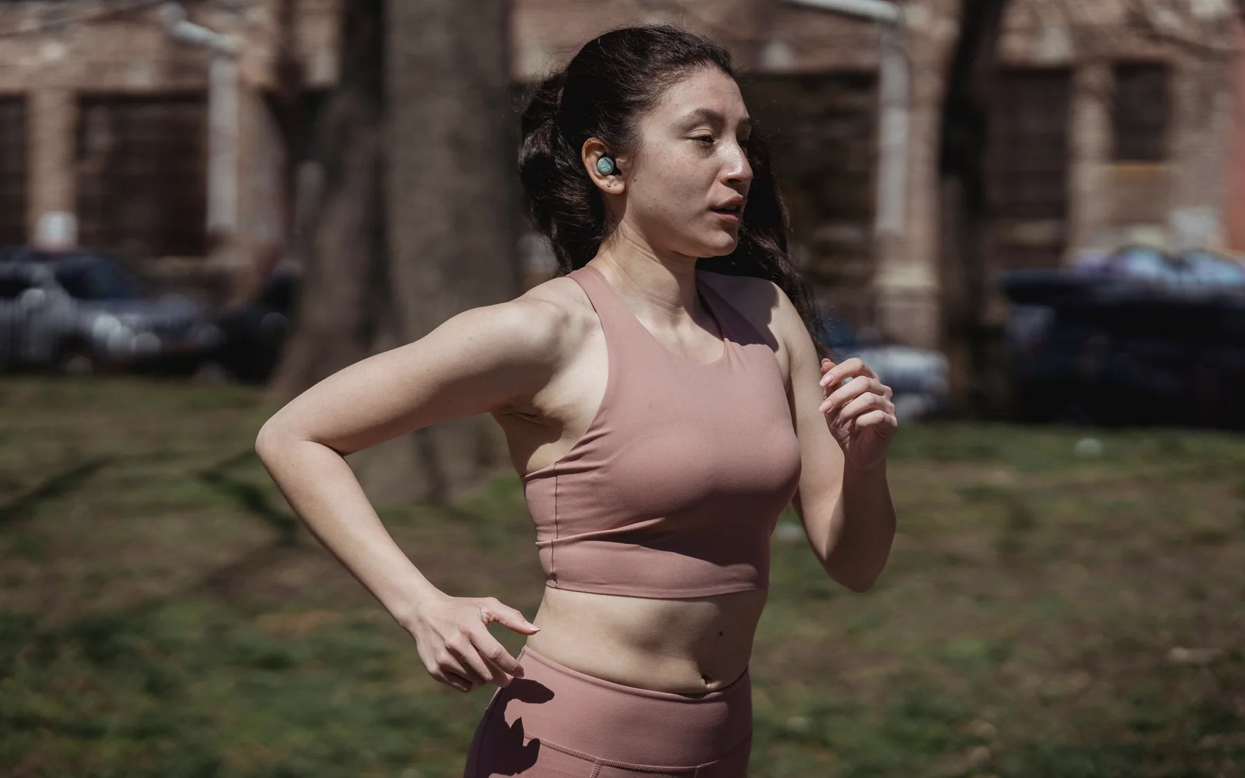A woman jogging at a comfortable pace through a city park