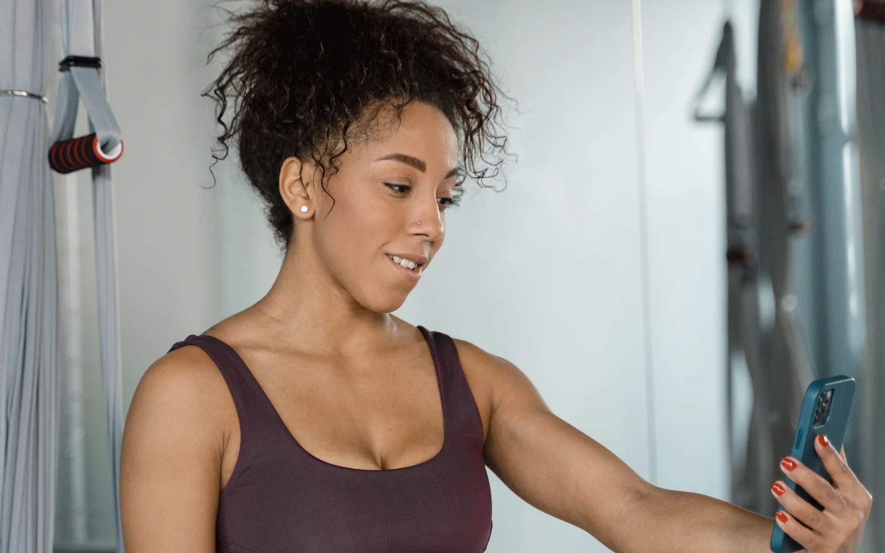 A woman using her phone to record a gym workout