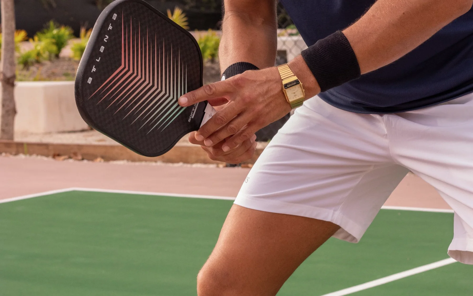 A pickleball player holding a paddle on an outdoor court