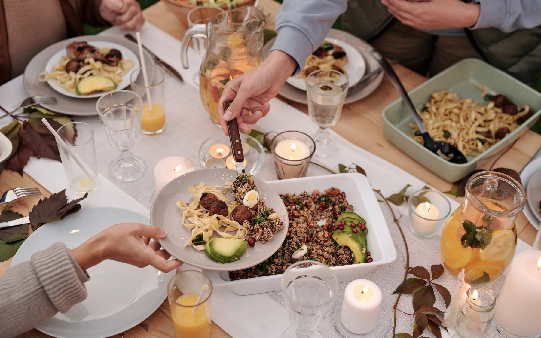 Friends serving a shared homemade meal around a table