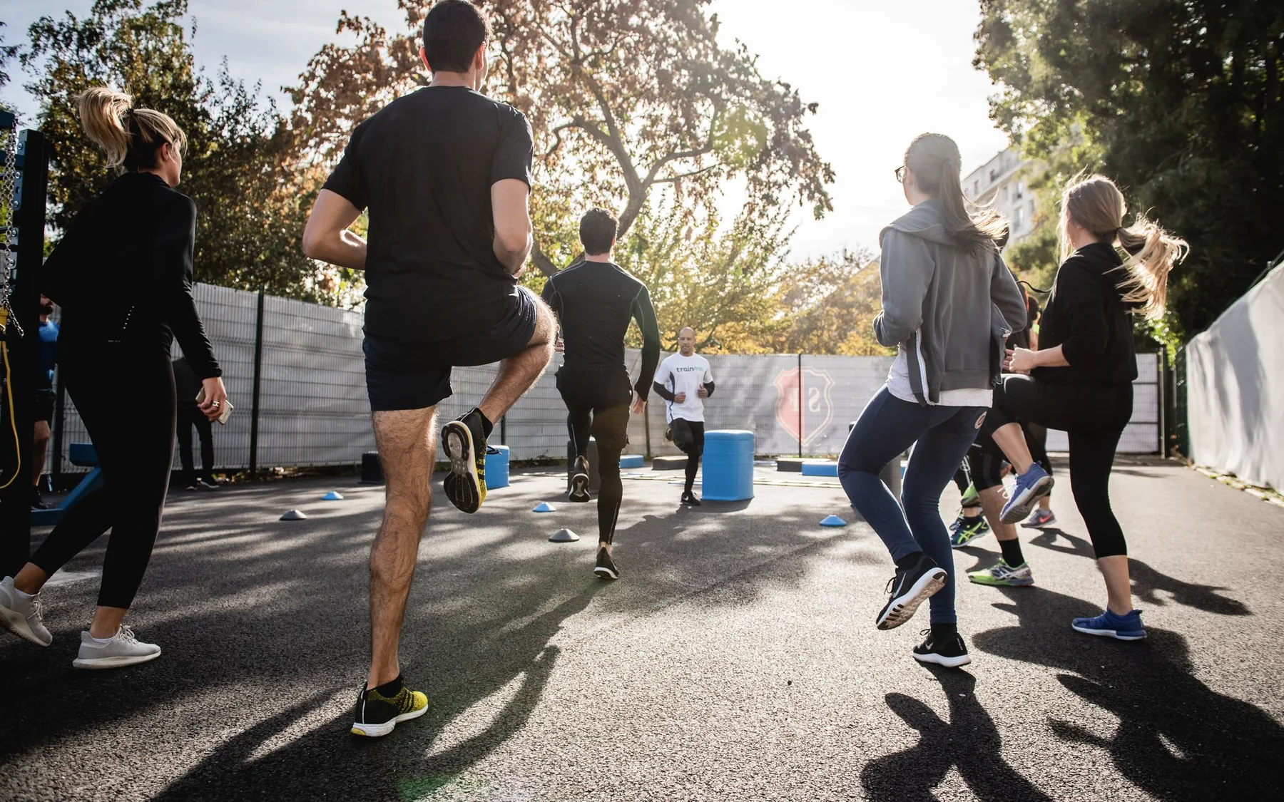 A mixed outdoor fitness group taking part in a shared movement session